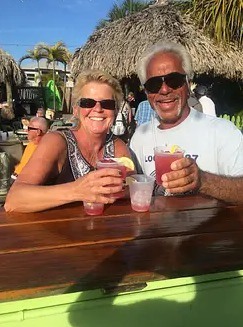 Barry Cupoli, former glioblastoma patient, and woman enjoying beverages in a tropical location