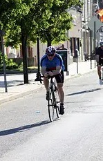 Mike Weems riding a bike in a triathlon after herniated disc treatment at IGEA Brain and Spine